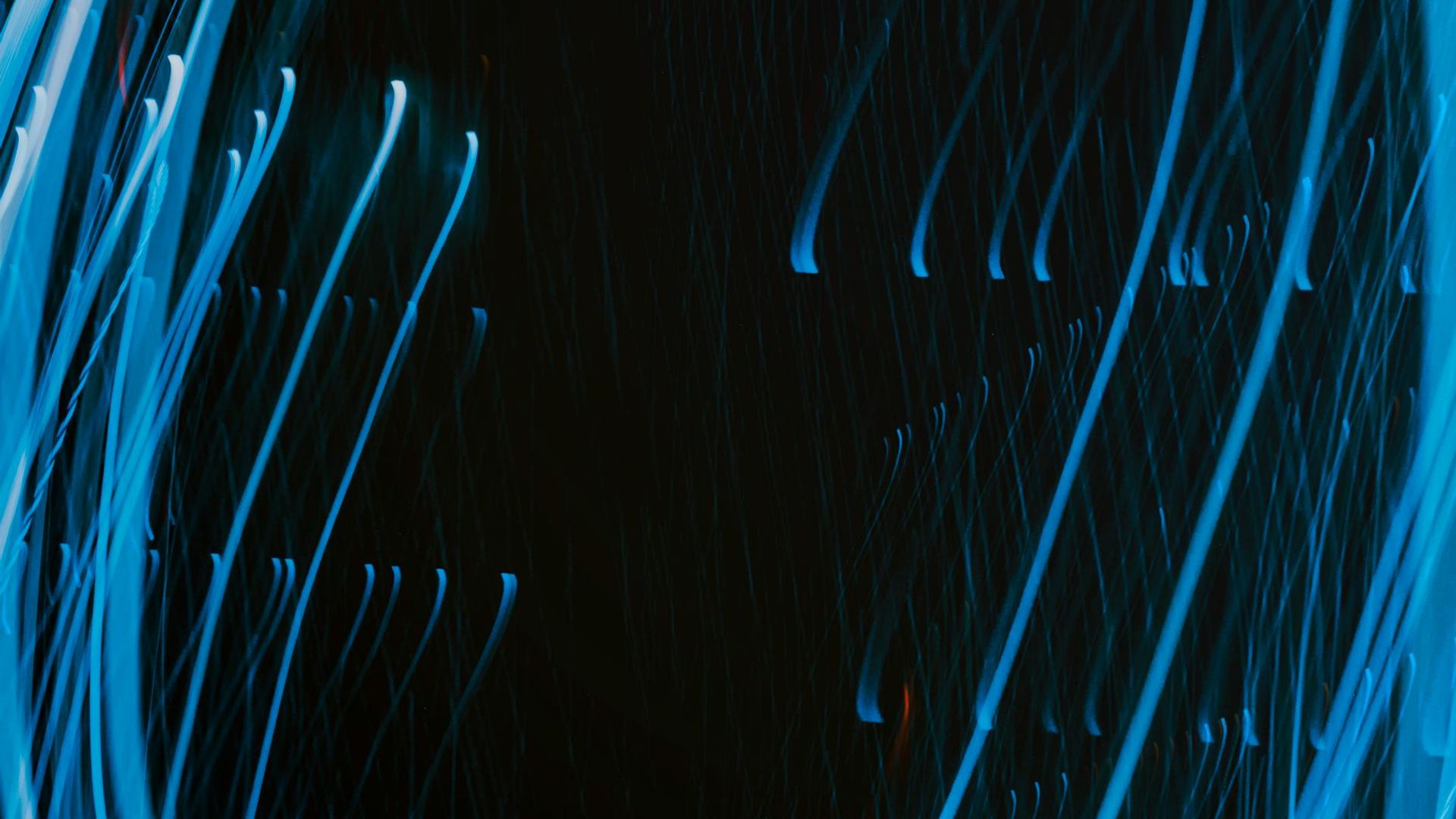 Abstract flowing light trails on a dark background.