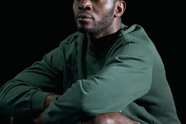 Person in a calm, focused pose in a minimalist studio.